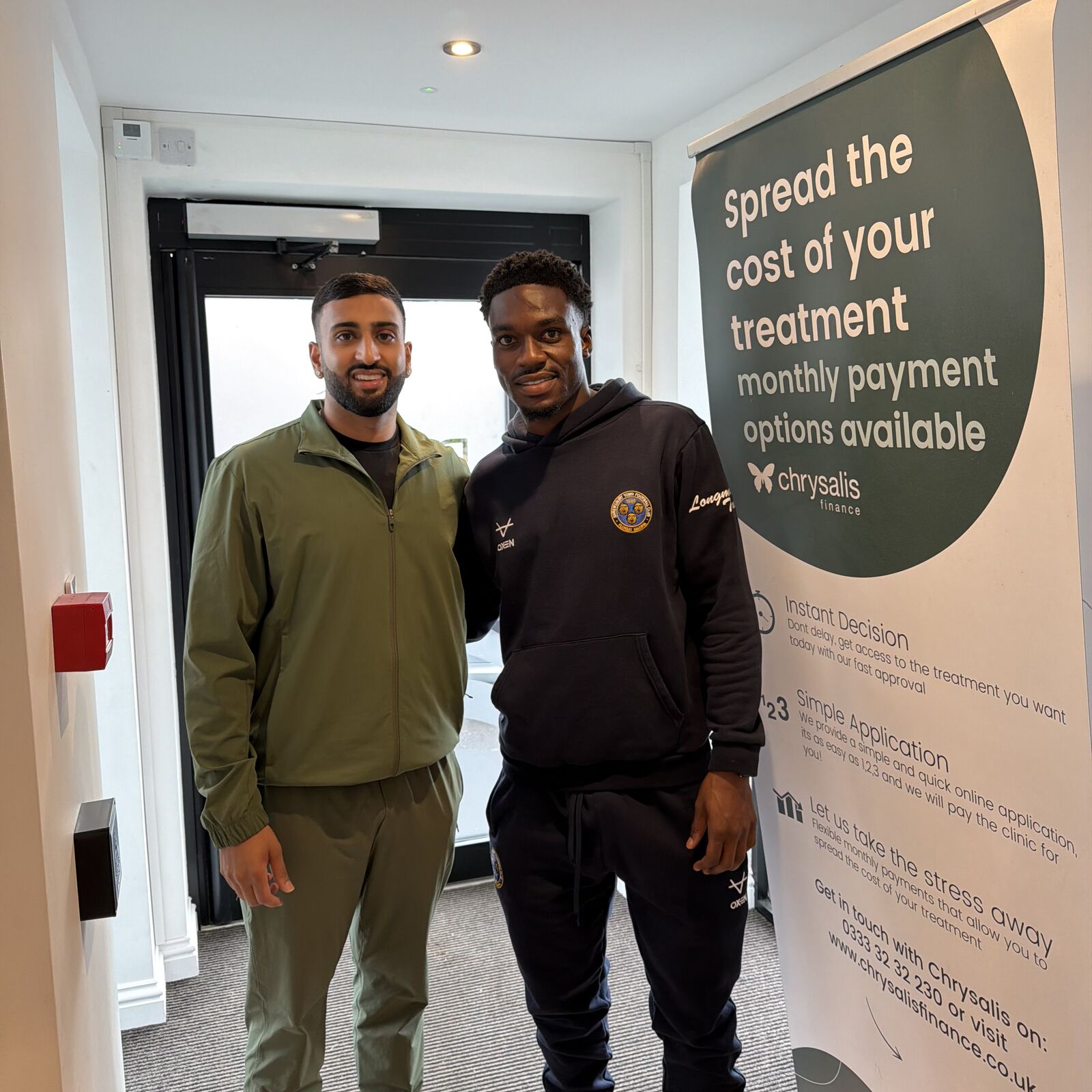 Dr Cameron Bagry with a patient beside the Chrysalis finance banner at the practice