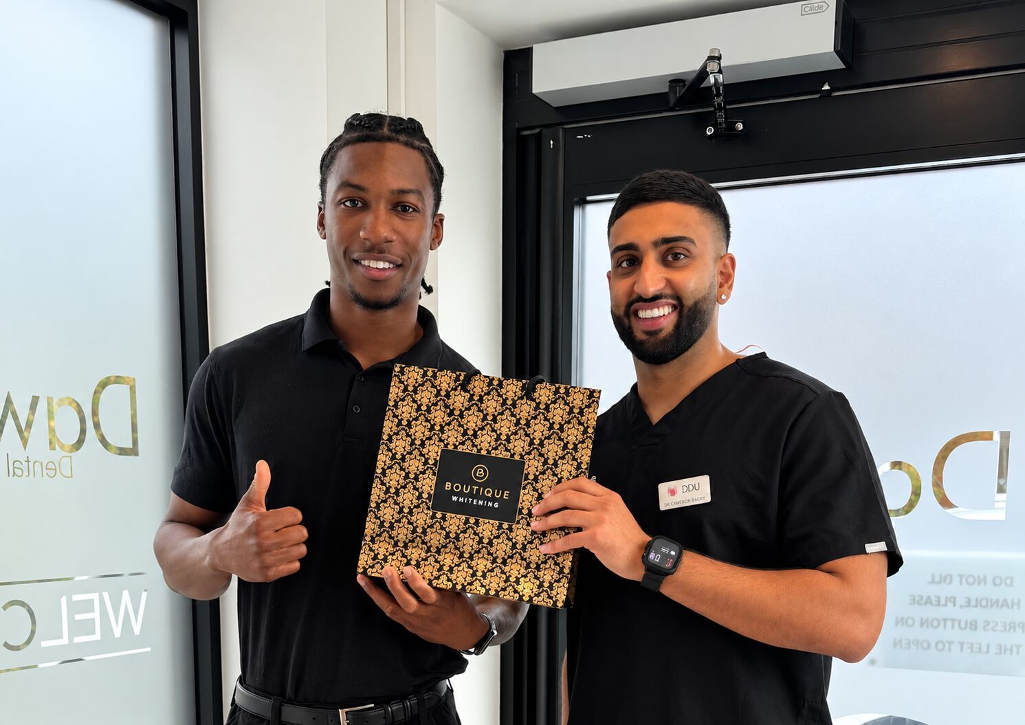 Cameron with a patient holding his Boutique Whitening kit at the practice