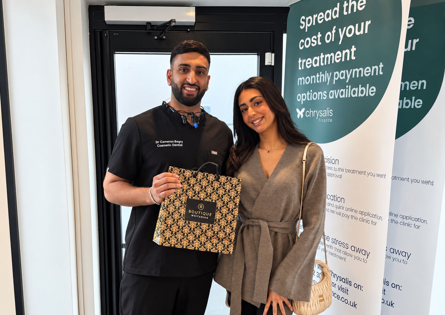 Cameron with a patient holding her Boutique Whitening gift bag at the practice